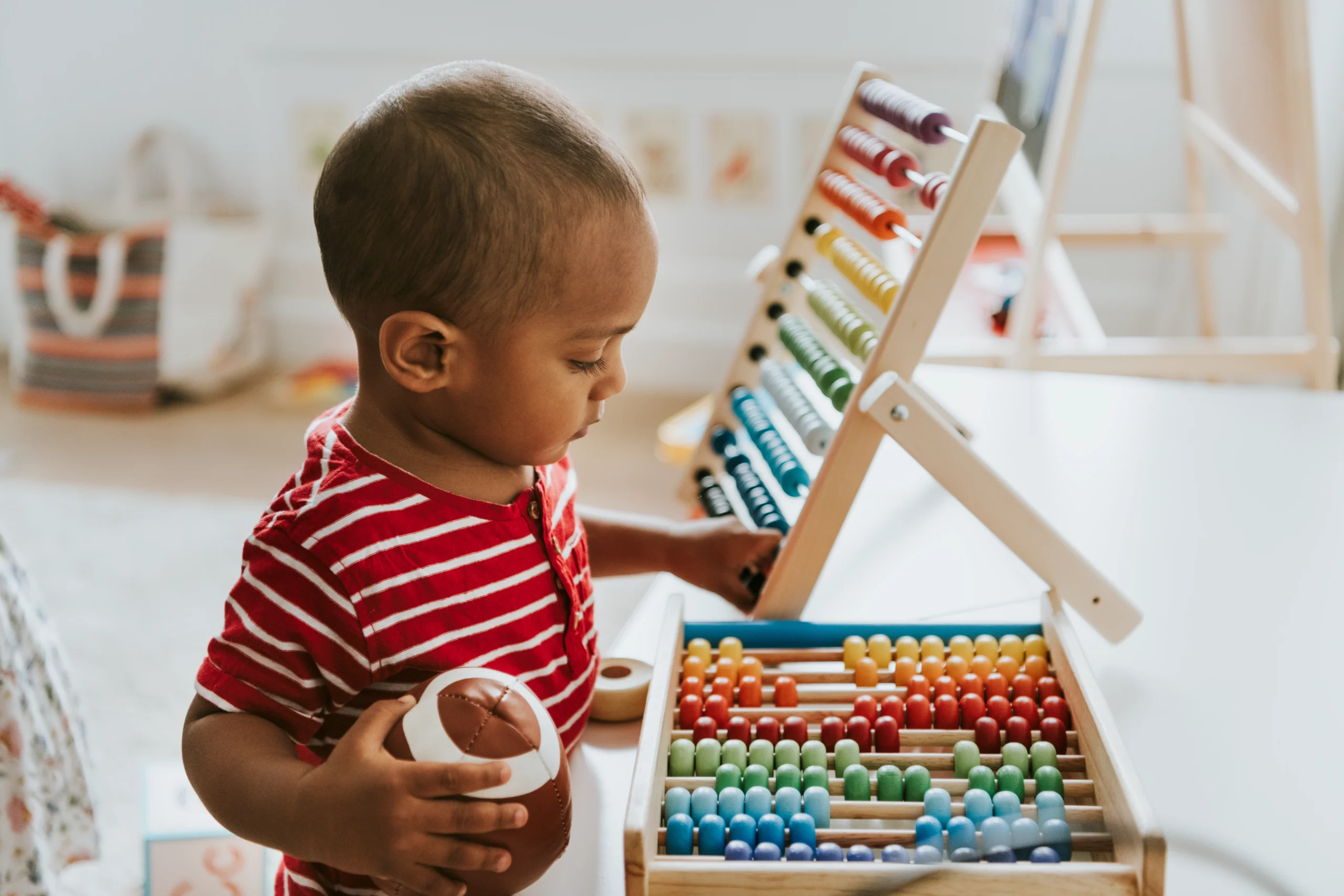 Kid playing with colorful wooden abacus